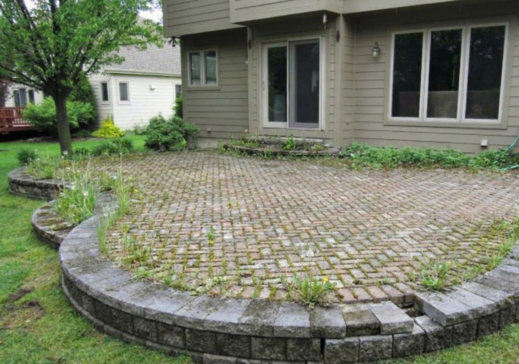 Sunken and uneven interlock patio in London Ontario before professional relevelling and cleaning by Core Exteriors